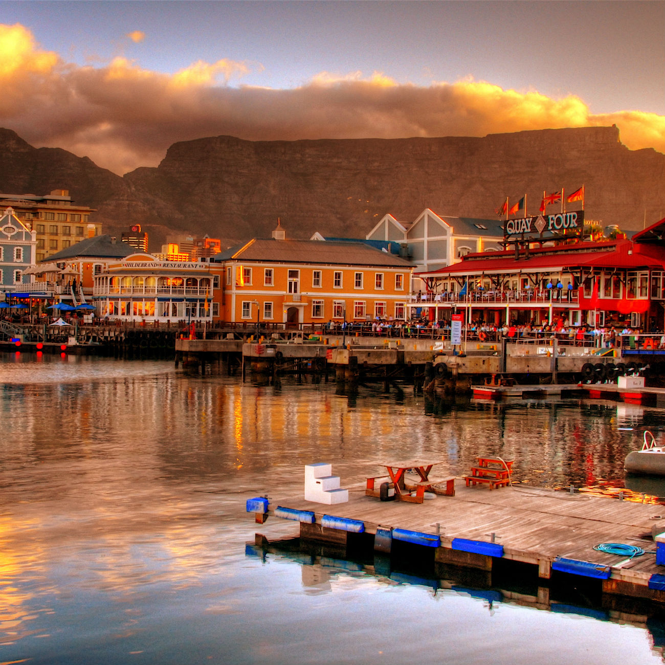 A harbor with a few boats and colorful buildings in Cape Town, South Africa