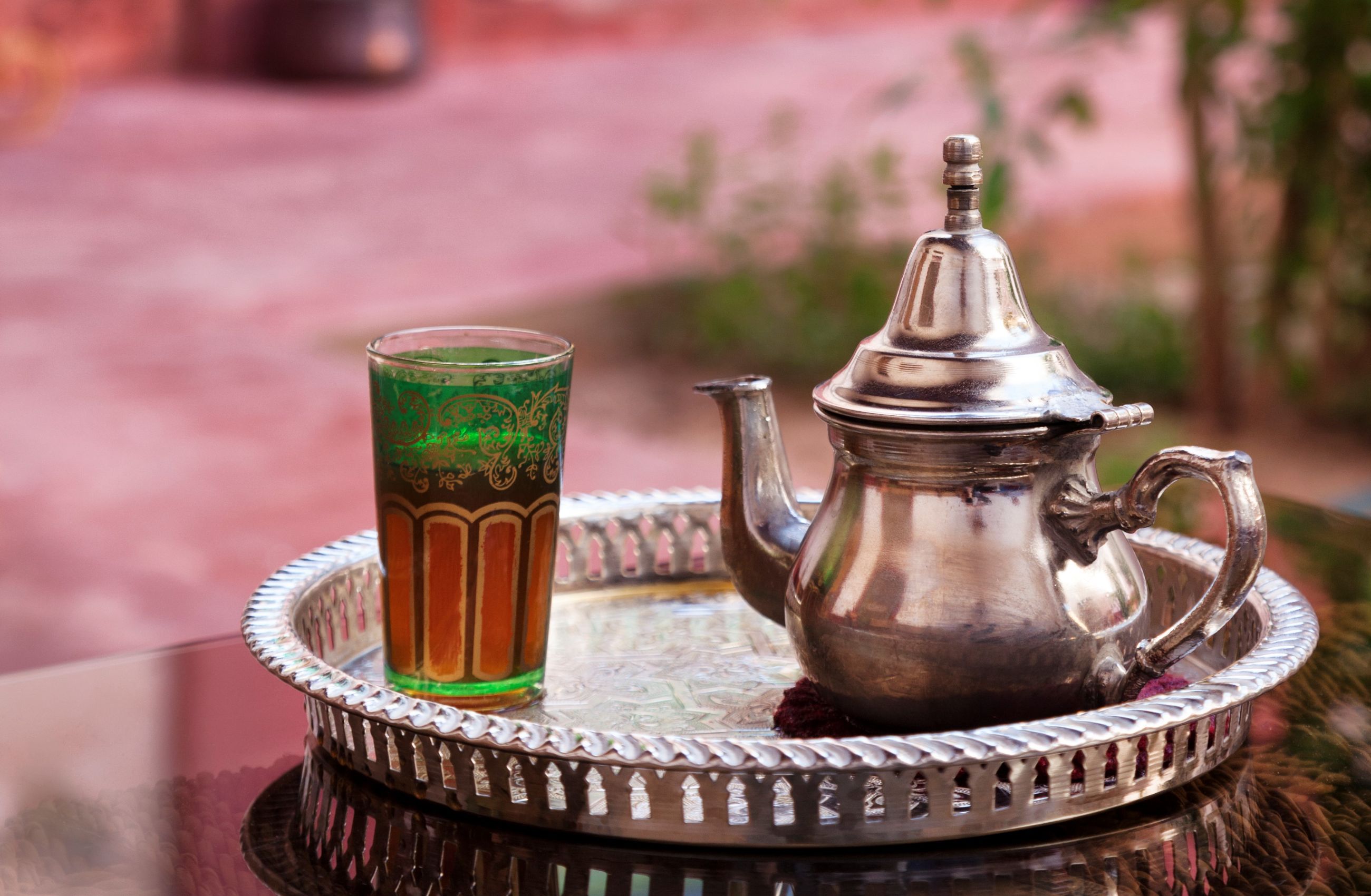 A pewter teapot and glass sit on a silver tray in a hammam in Marrakesh, Morocco.