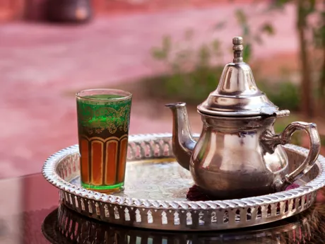 A pewter teapot and glass sit on a silver tray in a hammam in Marrakesh, Morocco.