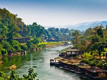 A landscape of lush green hills and houses in Kanchanaburi, Thailand