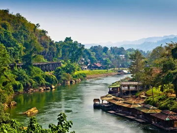 A landscape of lush green hills and houses in Kanchanaburi, Thailand