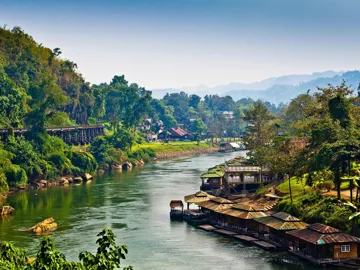 A landscape of lush green hills and houses in Kanchanaburi, Thailand