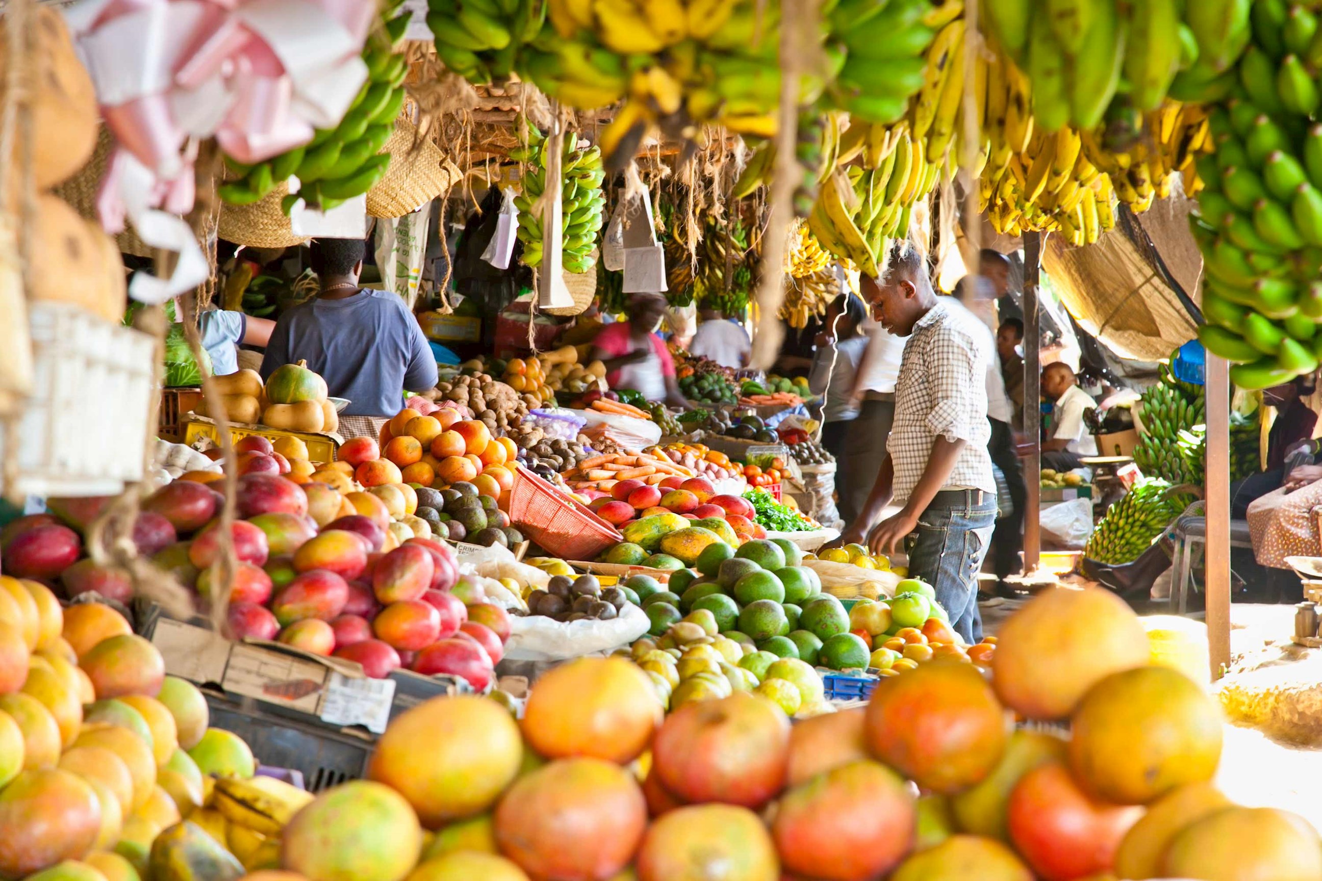 Colourful fruit market with bananas, mangoes and vendors in Nairobi, Kenya