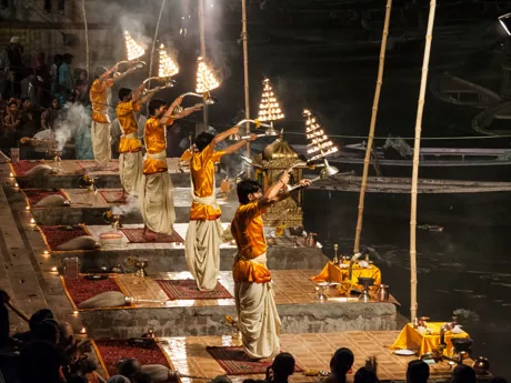 People dressed in gold clothing participate in the Aarti ceremony on the Ganges River in India.