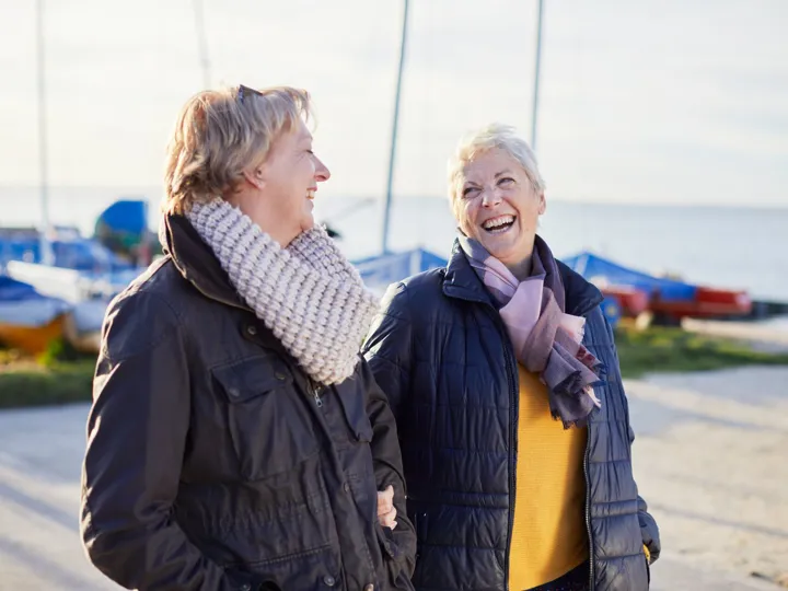 affectionate-lesbian-couple-walking-by-sea-1157117557.jpg