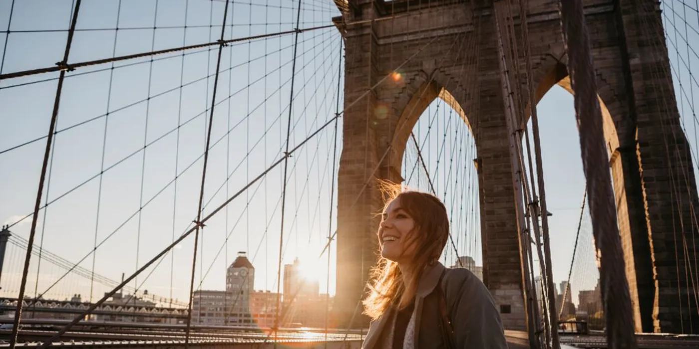 Usa New York New York City Female Tourist On Brooklyn Bridge At Sunrise