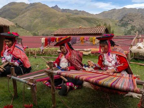 Three local weavers in colourful traditional dress in Peru