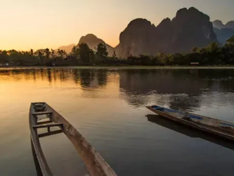 Mekong River at sunset with wooden boats in the foreground, Thailand