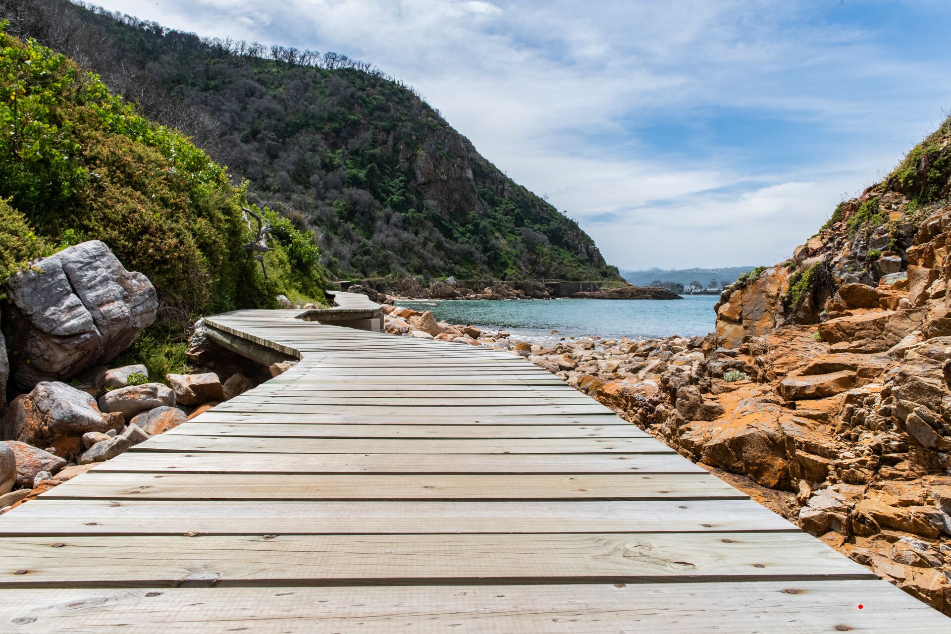 A wooden walkway leading to a rocky beach in Featherbed Nature reserve. South Africa