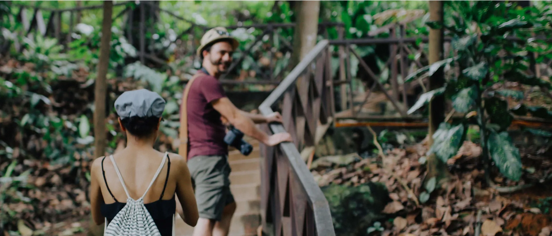 Two Costsaver guests walking up stairs surrounded by trees