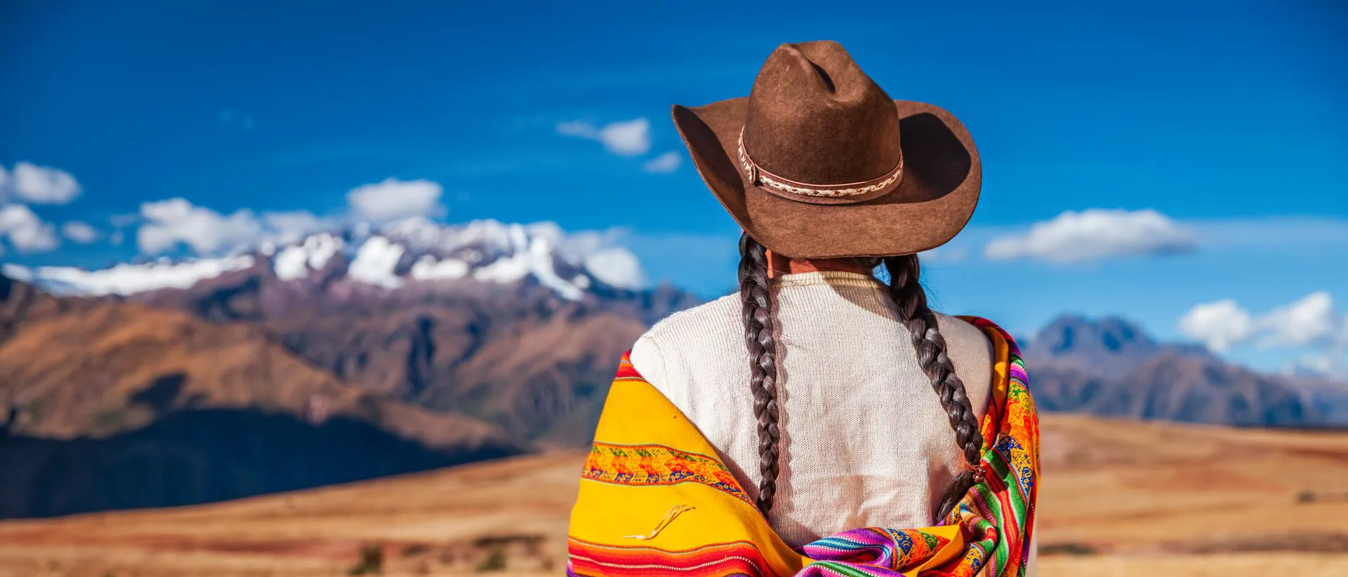 Peruvian Woman In National Clothing Looking At Andes in The Sacred Valley