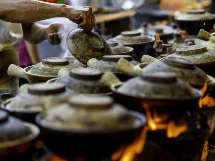 Clay pots lined up over a fire. A traditional method of cooking in Singapore.