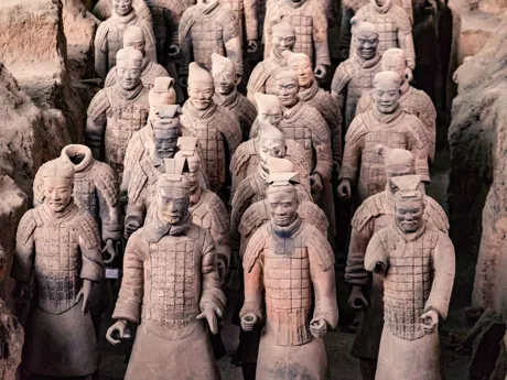 Rows of the famous terracotta warriors in China, carved wearing their traditional battle costumes.