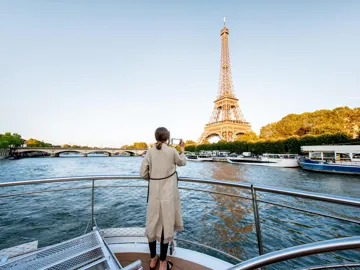A person on a boat against the Eiffel Tower on a sunny day in Paris, France