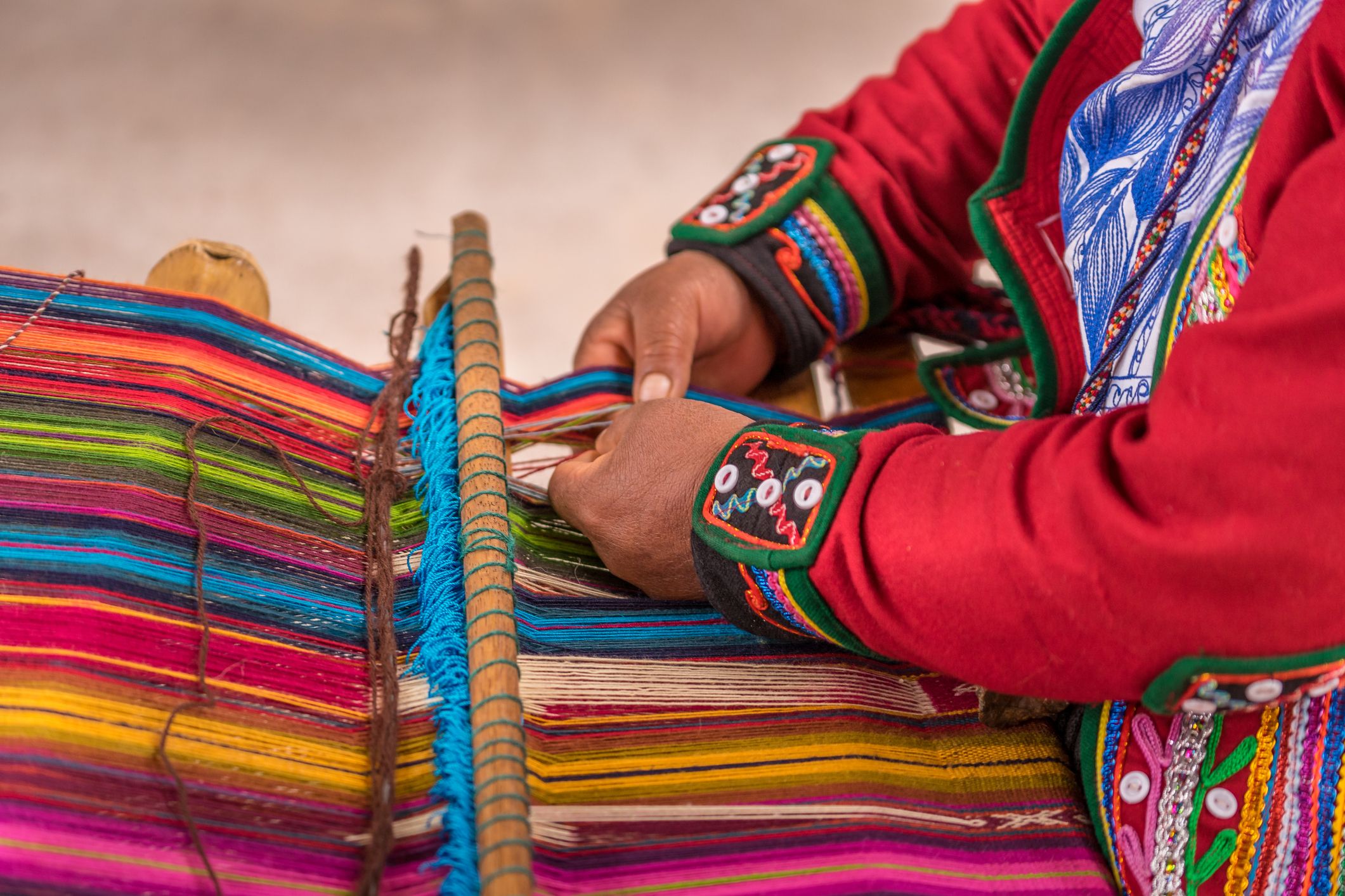 Woman weaving traditional fabrics in the Pisac Market, Peru