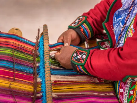 Woman weaving traditional fabrics in the Pisac Market, Peru