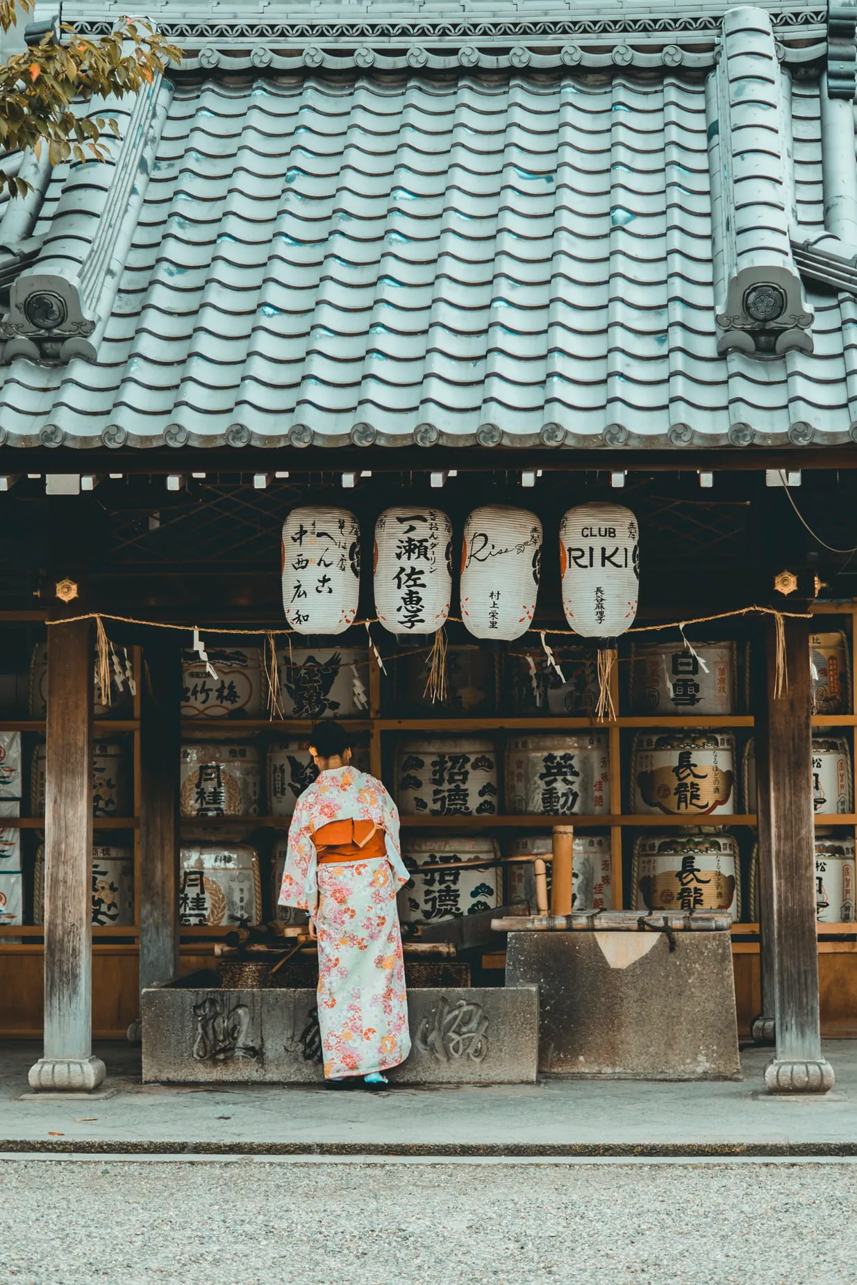 Woman in a traditional kimono in front of a shrine in Japan
