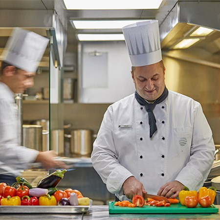 Two chefs preparing a meal on a cruise
