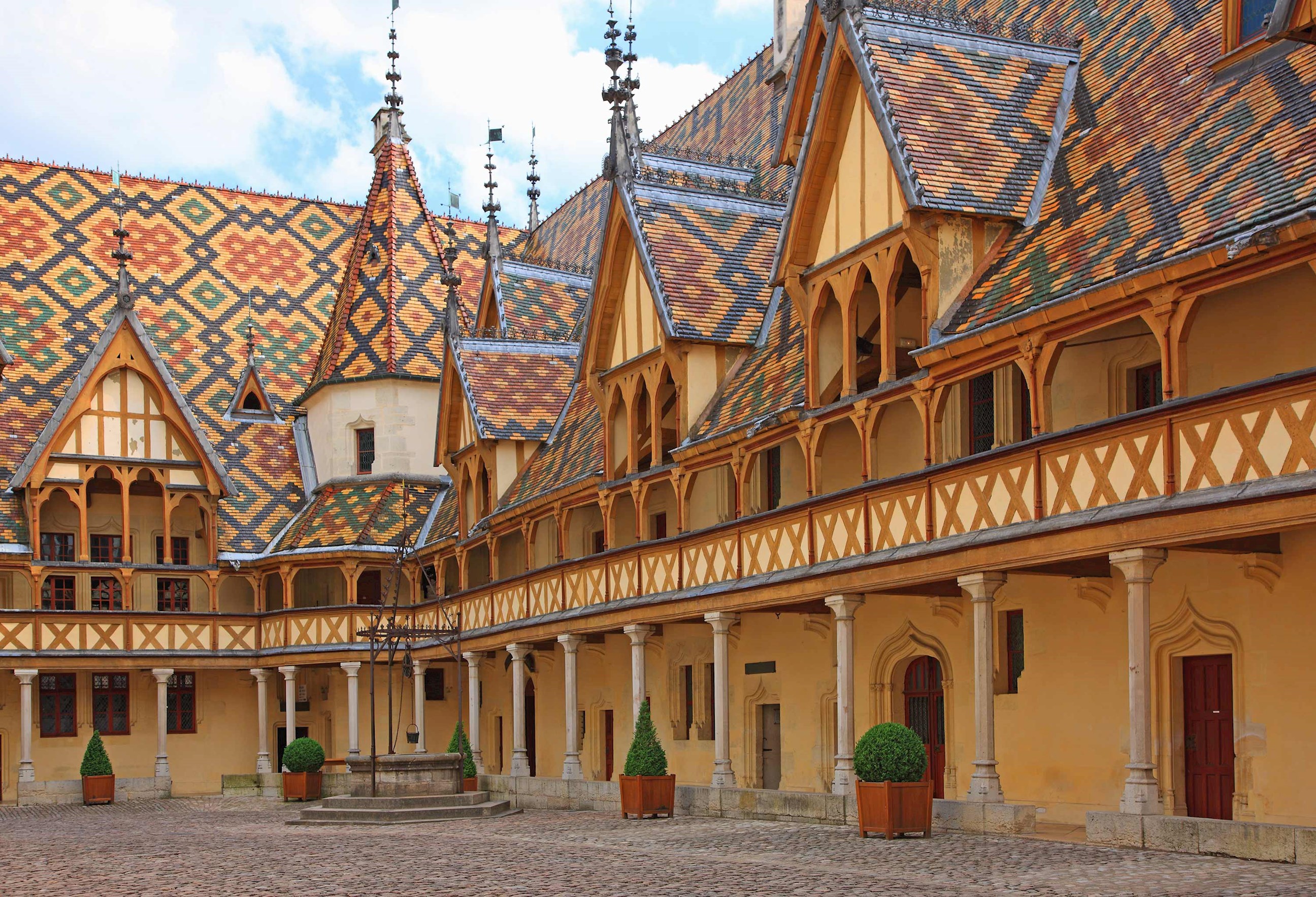 Panoramic view of Hospices de Beaune courtyard on a sunny day in Beaune, France