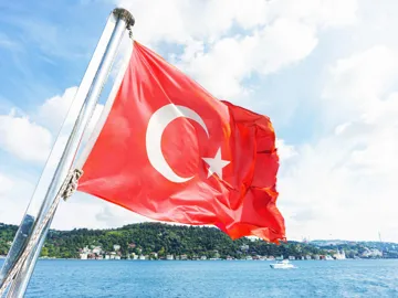Turkish flag waving on boat with sea and hills background