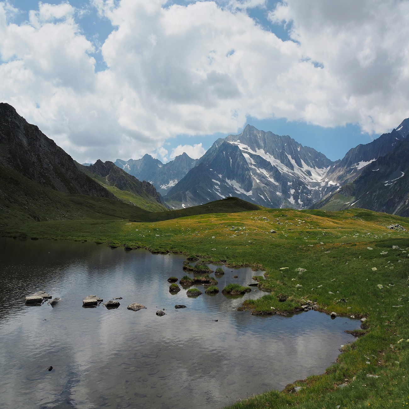 Lac du Pontet surrounded by mountains under a cloudy sky in Switzerland