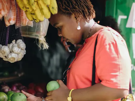 A woman shops for fruit at a market stall in Nairobi, Kenya.