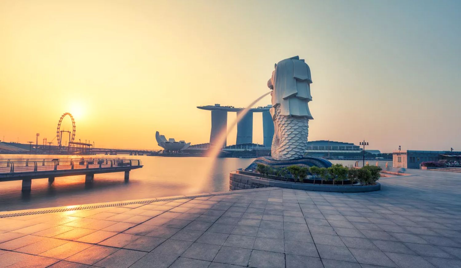 Lion statue with fountain of water spurting from mouth, Merlion Park with sunset in background, Singapore