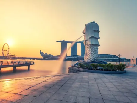Lion statue with fountain of water spurting from mouth, Merlion Park with sunset in background, Singapore