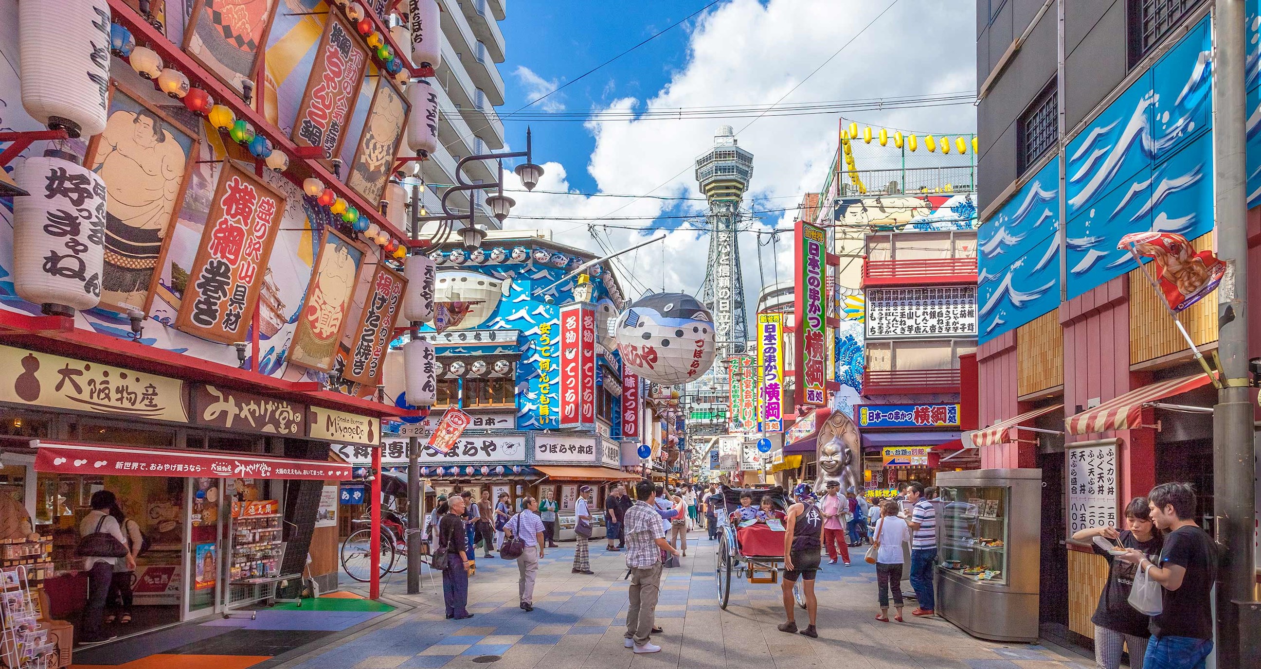 Colourful street in Osaka’s Shinsekai district with Tsutenkaku Tower view