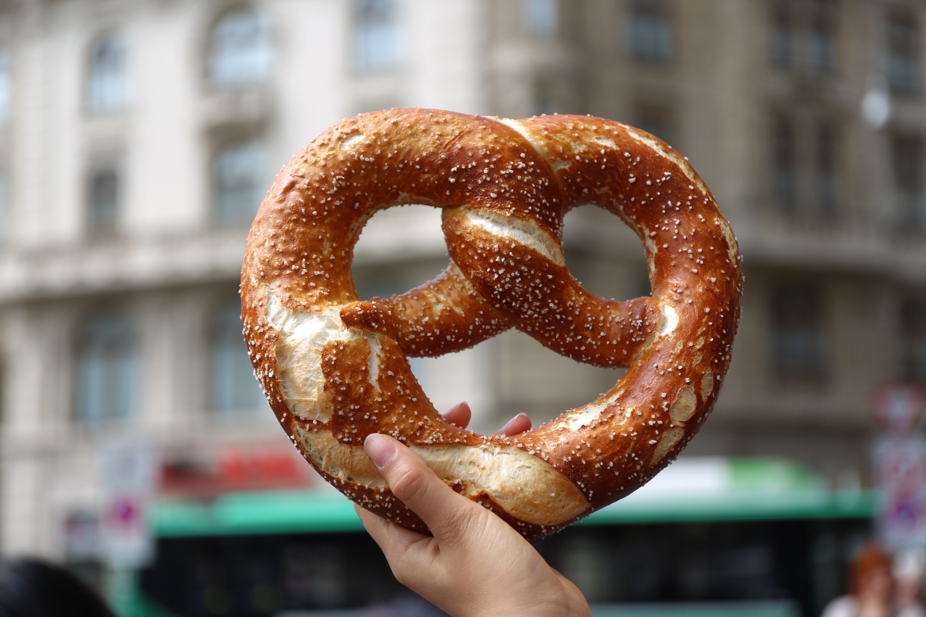 A hand holding up a giant pretzel