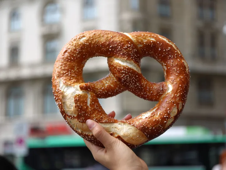 A hand holding up a giant pretzel