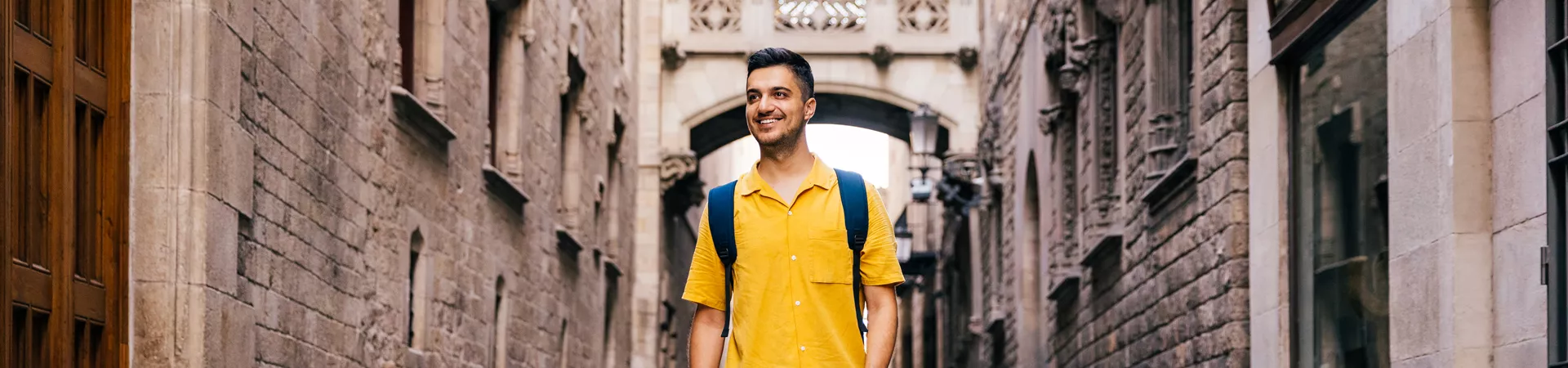 Young Happy Smiling Man Walking In The Streets Of Gothic Quarter In Barcelona, Spain
