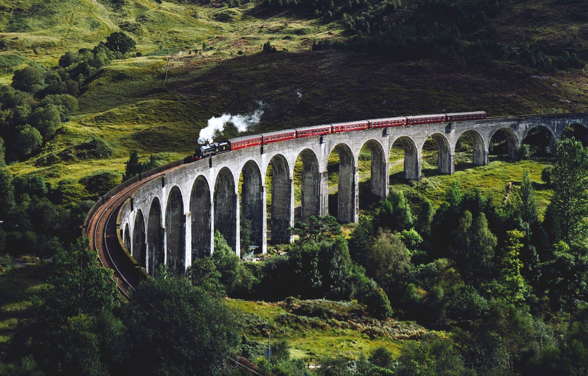 Glenfinnan Viaduct in Scotland with steam train on, famous from Harry Potter
