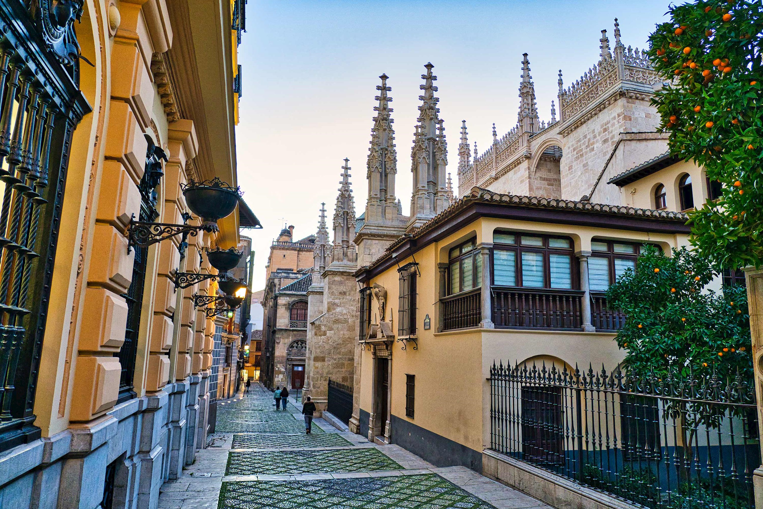 Cobblestone street lined with buildings and cathedral in Granada, Spain