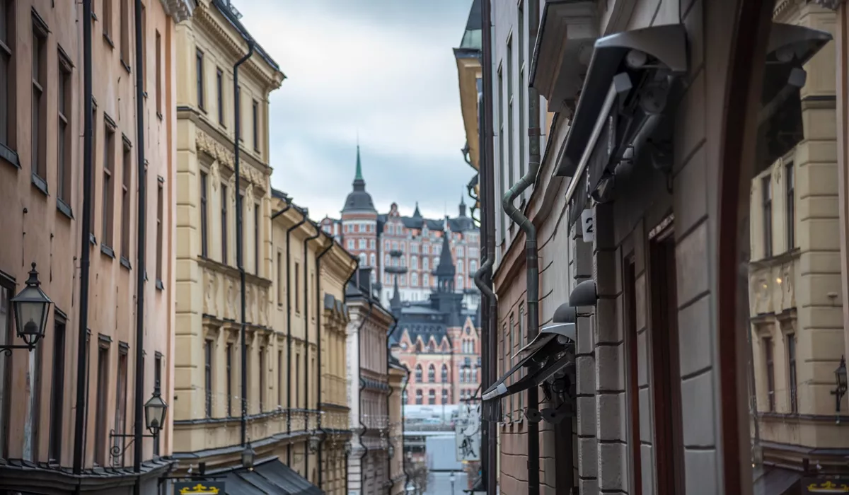 A narrow city street with buildings on both sides in Gamla Stan, Sweden