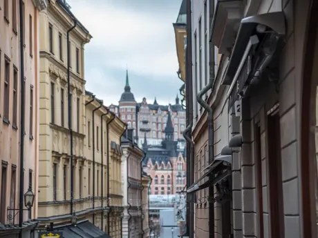 A narrow city street with buildings on both sides in Gamla Stan, Sweden