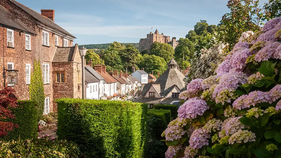 sunny-day-in-the-exmoor-village-of-dunster-with-ancient-buildings-and-blooming-flowers-1445919796.webp