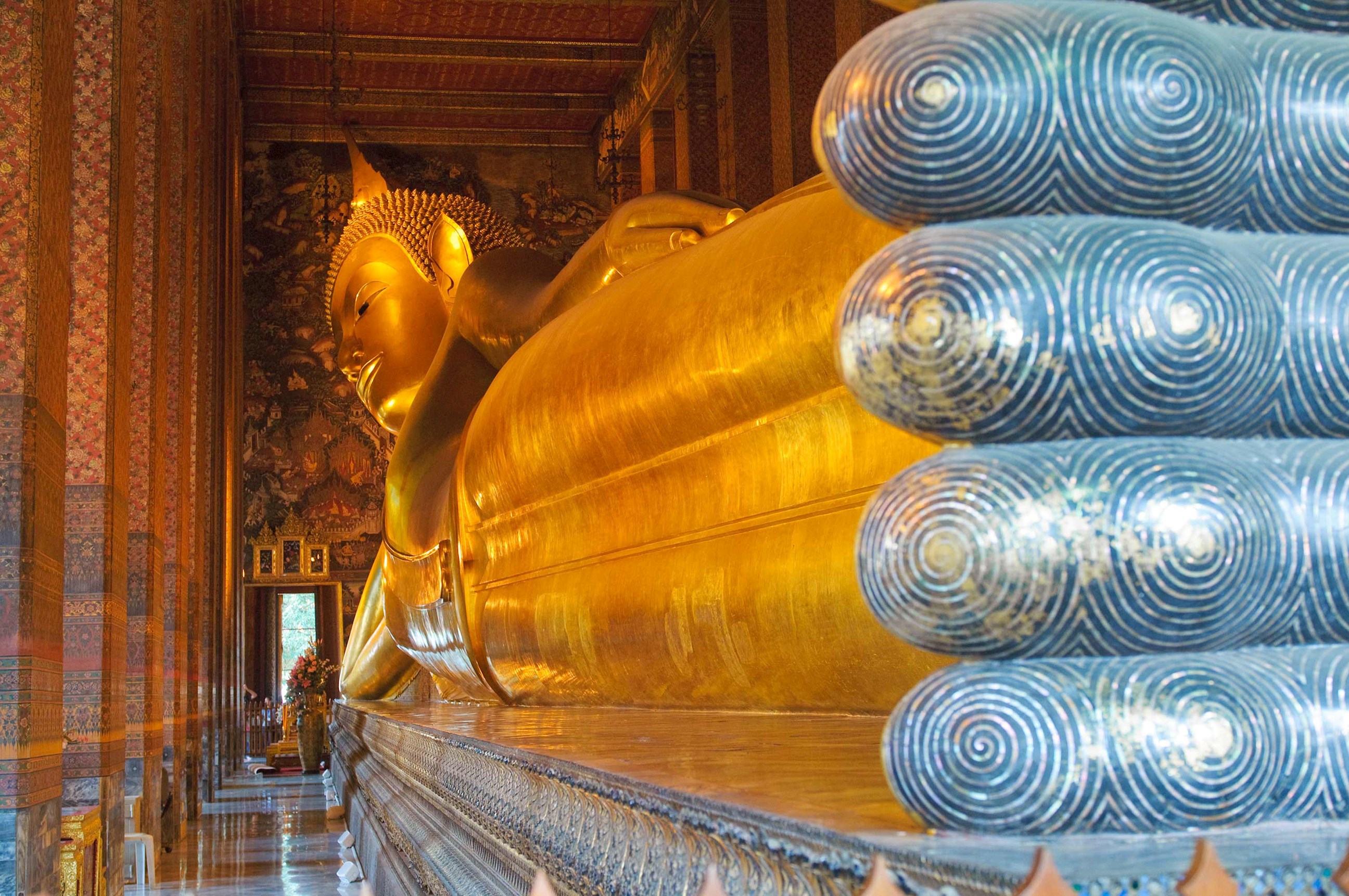 Golden Reclining Buddha statue inside hall at Wat Pho Bangkok