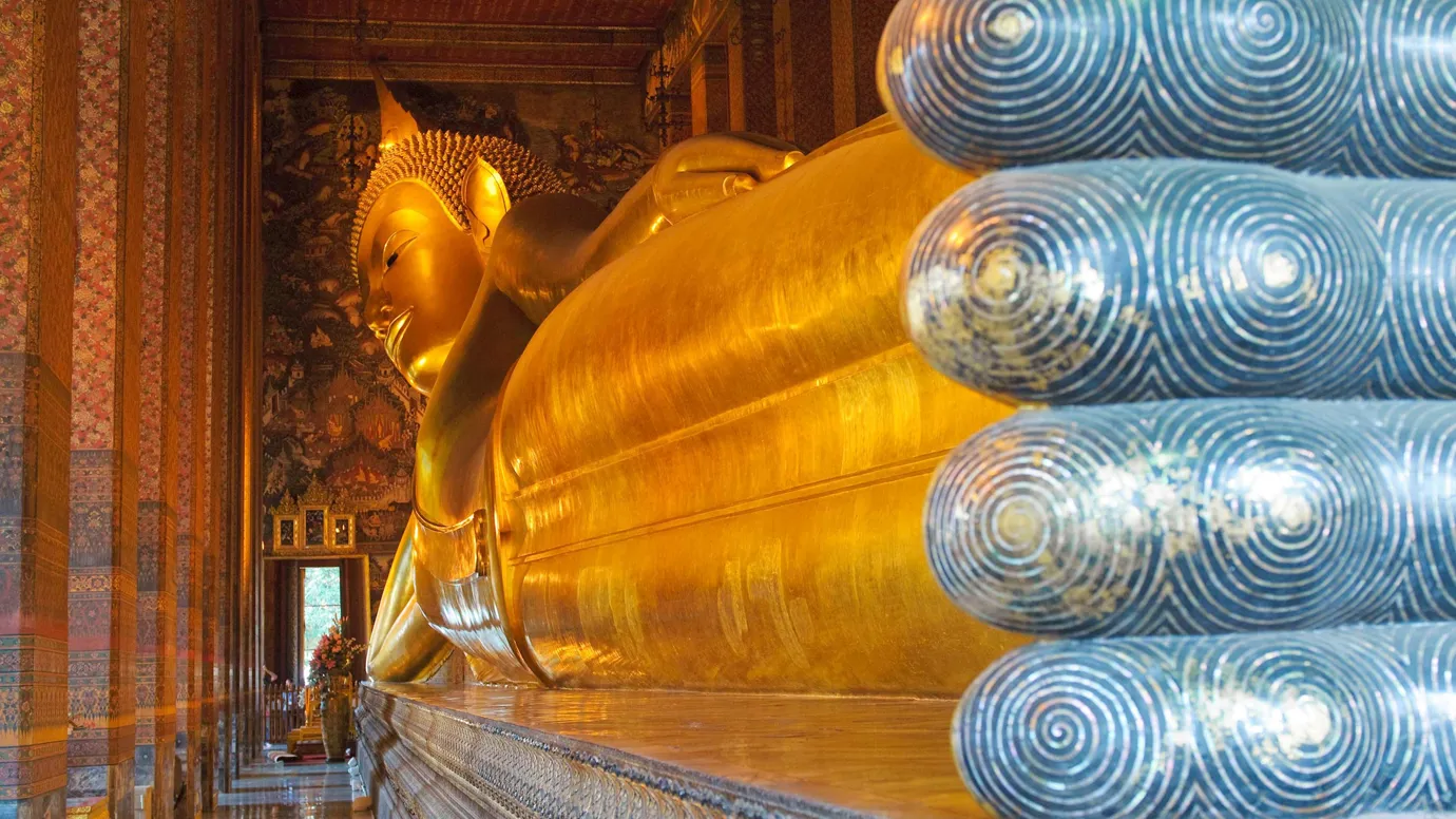 Golden Reclining Buddha statue inside hall at Wat Pho Bangkok