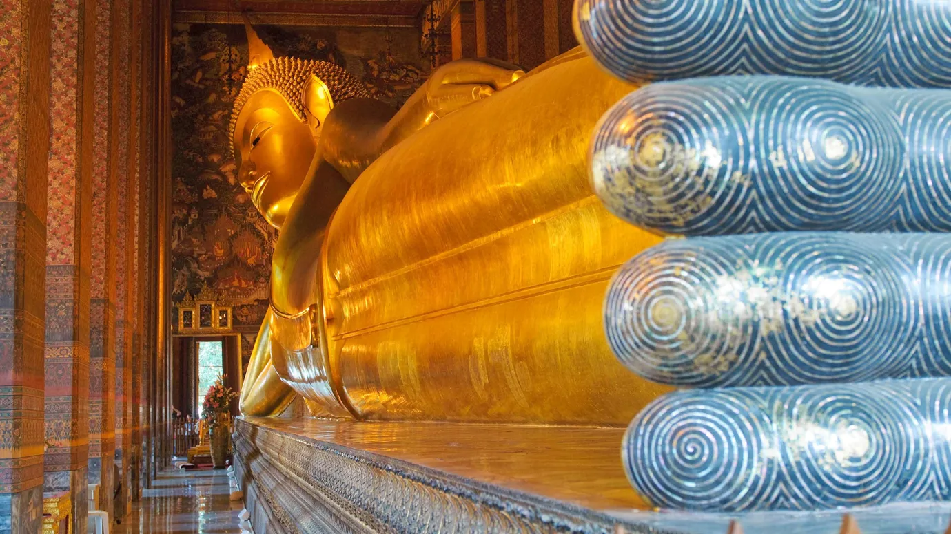 Golden Reclining Buddha statue inside hall at Wat Pho Bangkok