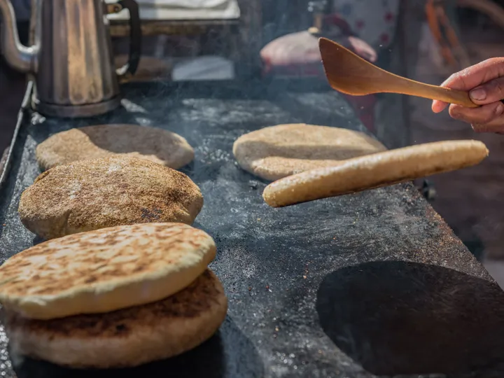 Moroccan flatbreads being cooked and flipped over