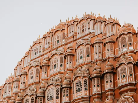 The Palace of Winds in Jaipur, India, built in red stone with many highly decorated windows.