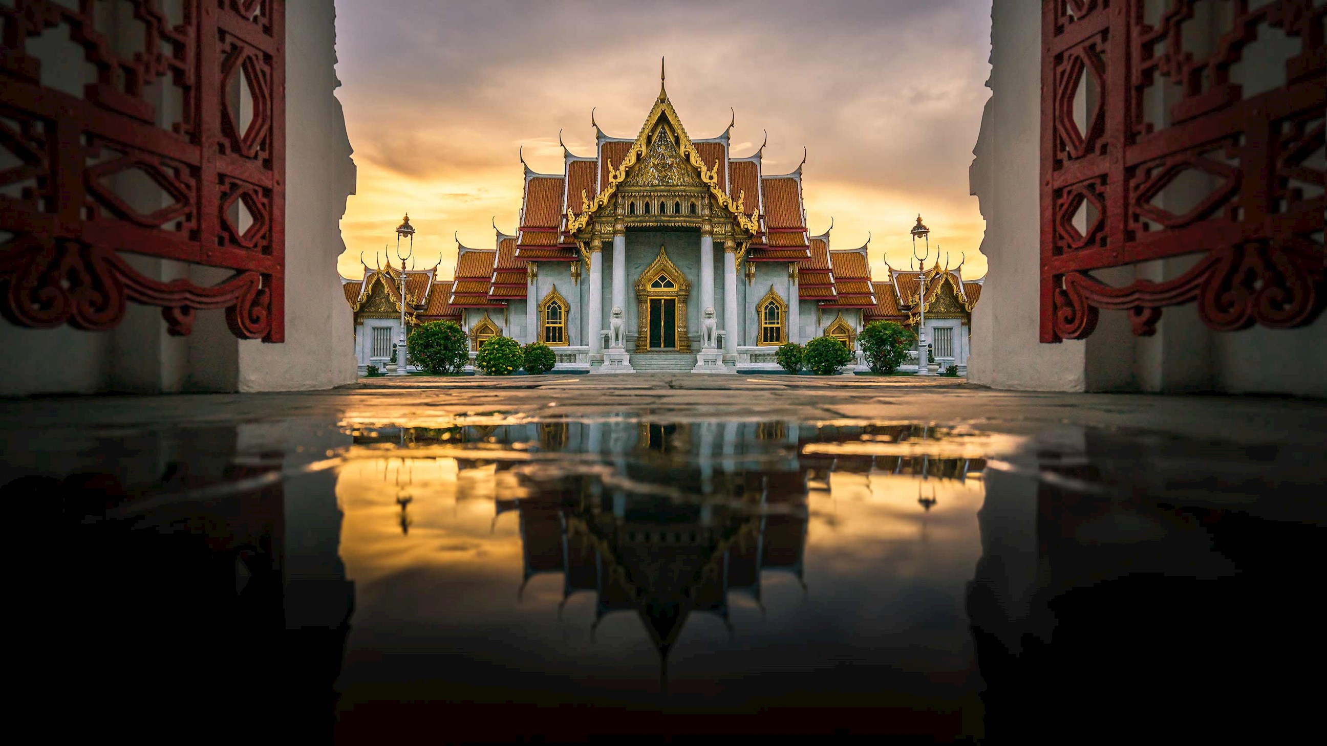 Marble Temple reflecting in water at sunset in Bangkok, Thailand