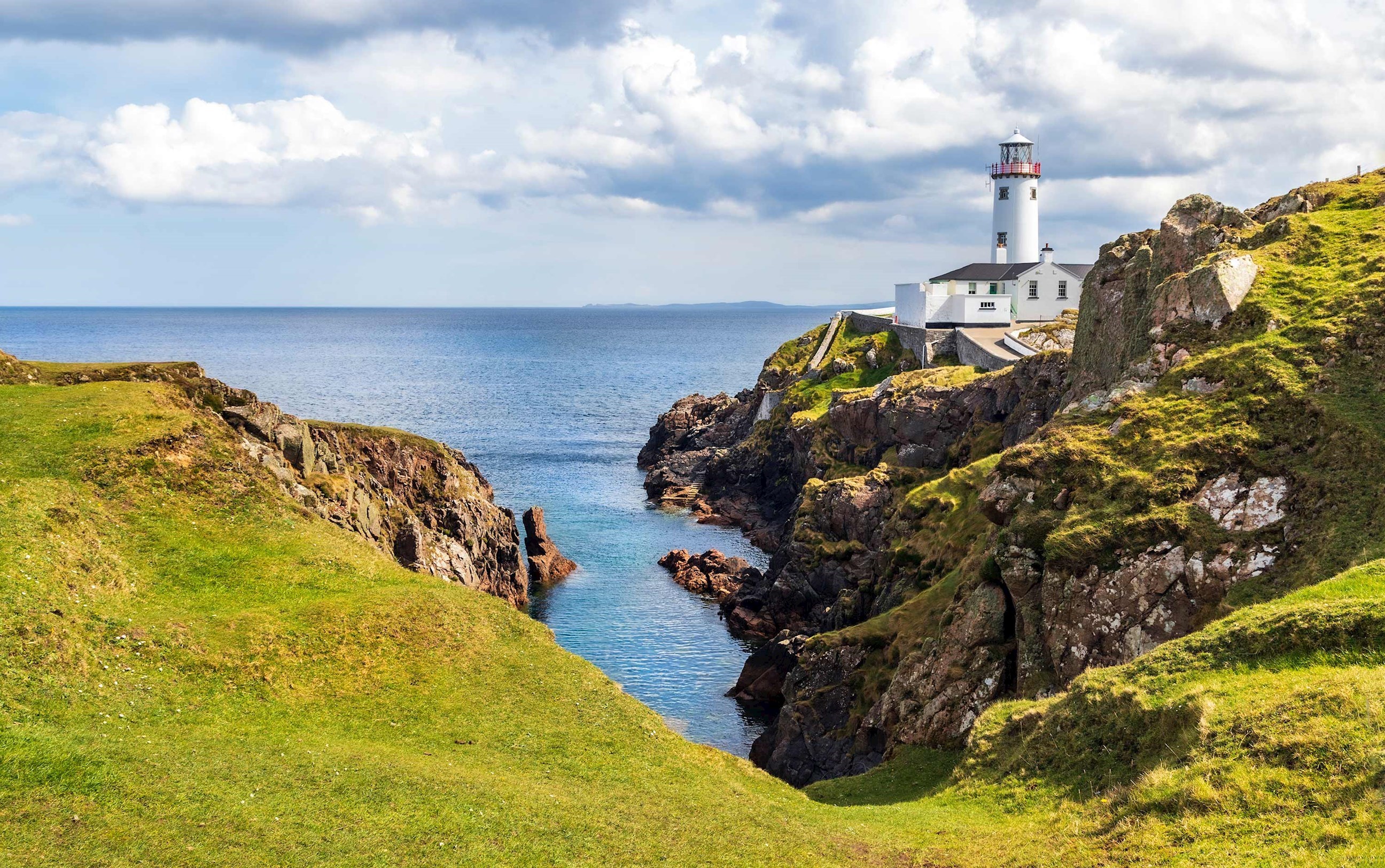 Lighthouse overlooking cliffs against clear skies in County Donegal, Ireland