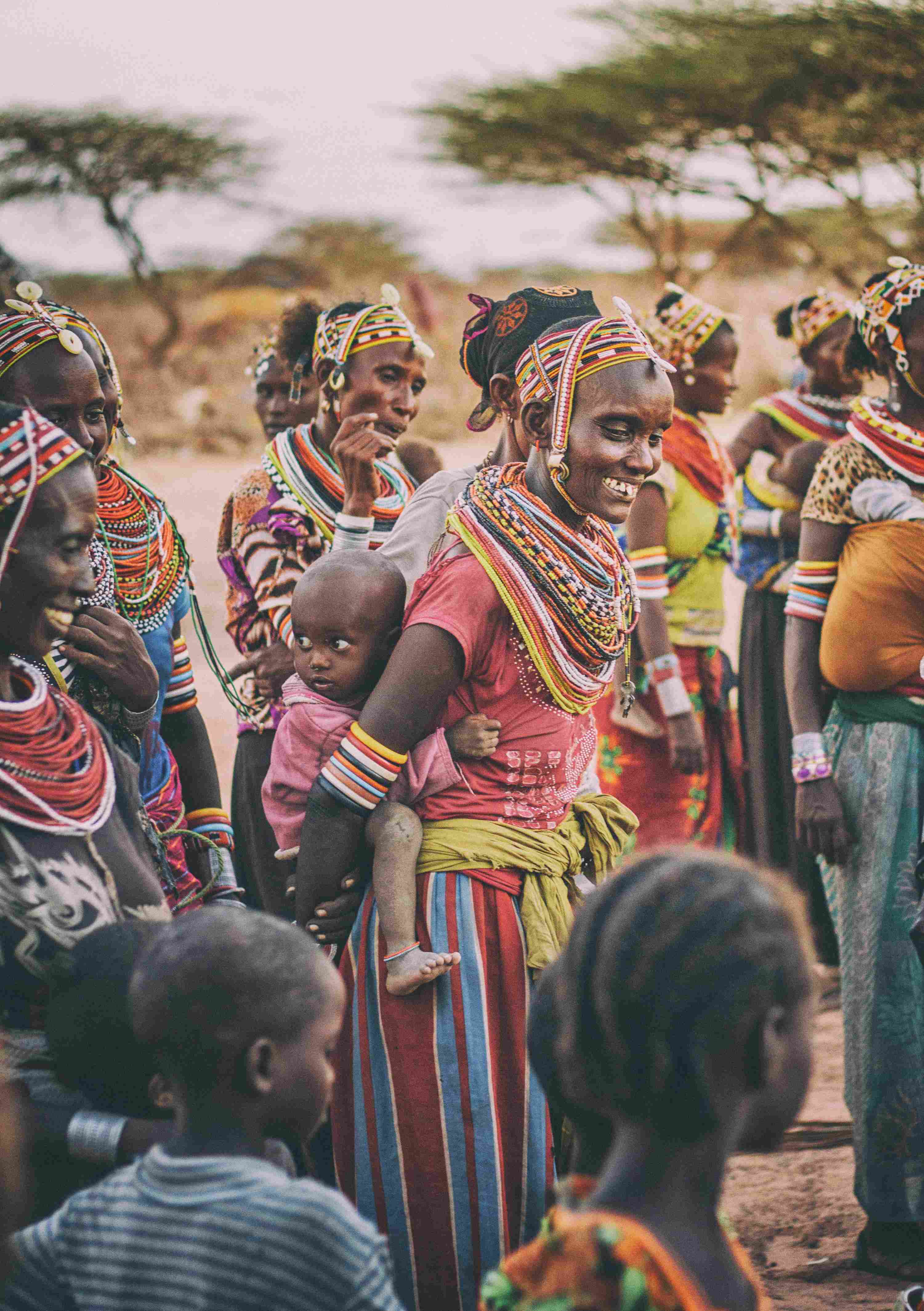 Kenyan ladies and children in traditional dress smiling