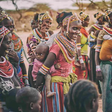 Kenyan ladies and children in traditional dress smiling