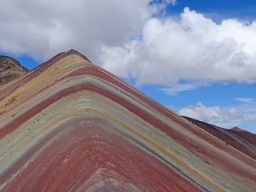 Traveller walking over the Rainbow Mountain during a hike in Cusco, Peru