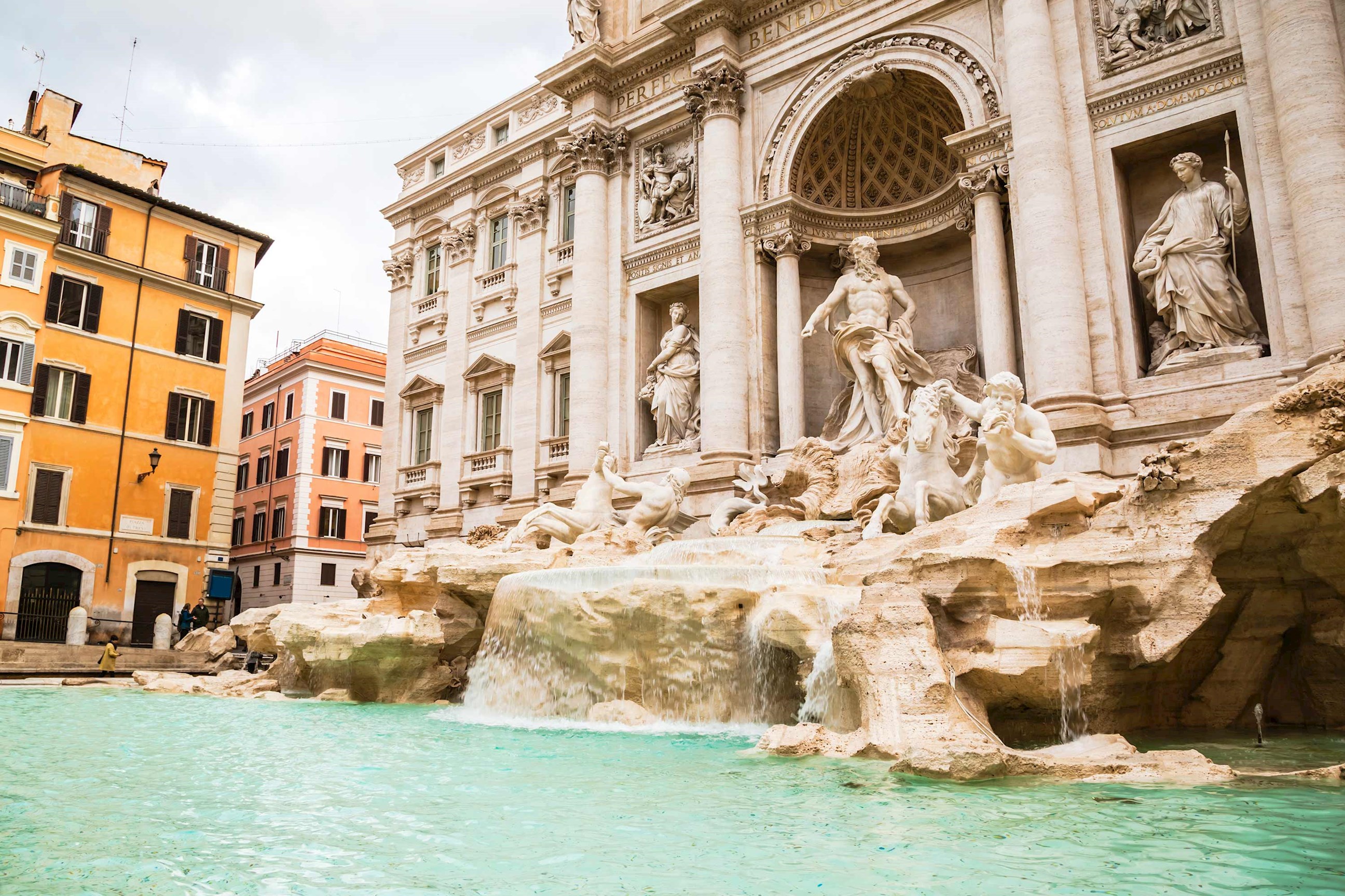 Close view of the Trevi Fountain with sculptures and turquoise water in Rome, Italy