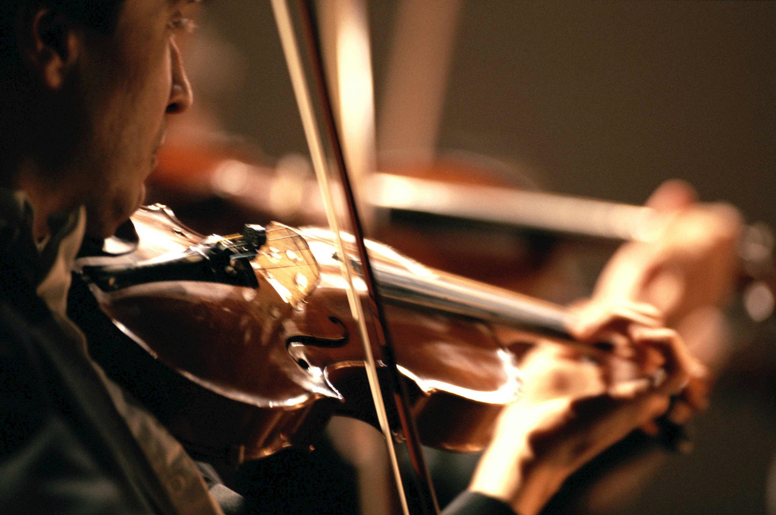 Violinist performing with bow in focus in Vienna, Austria