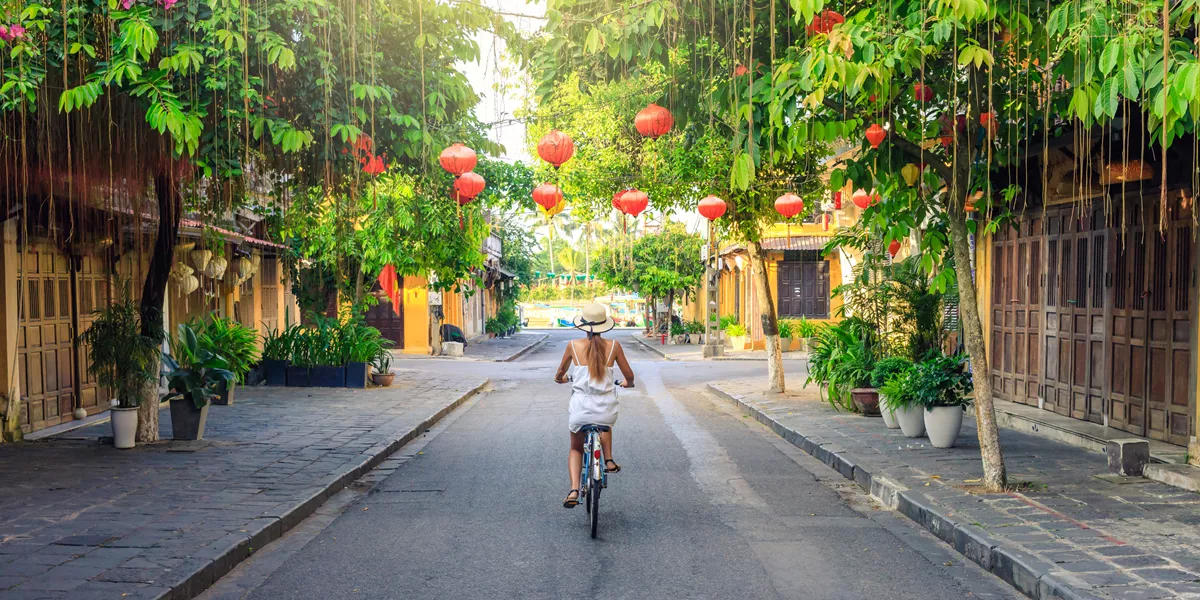 Woman biking across green Hoi An, Vietnam